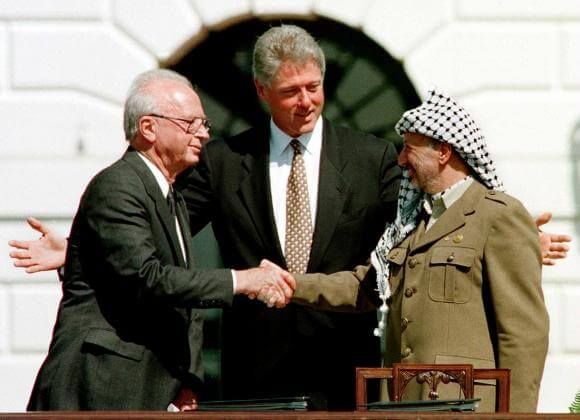 Rabin e Arafat si stringono la mano, sotto l’occhio di Clinton